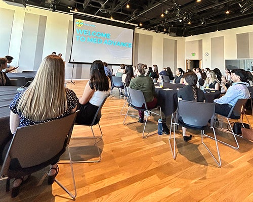 Students sit at tables in the Redwood Auditorium