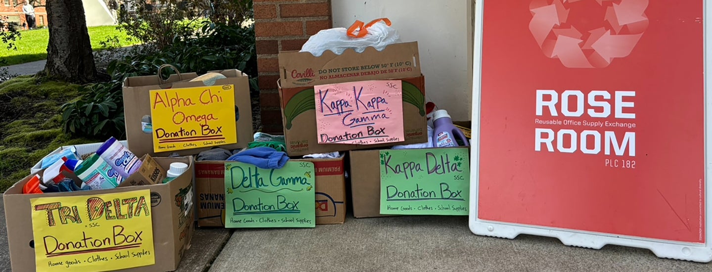Boxes of donated clothes and school supplies sit next to a sign that says Rose Room.