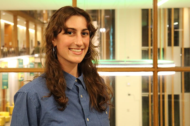 Young woman with long dark hair wearing a blue shirt