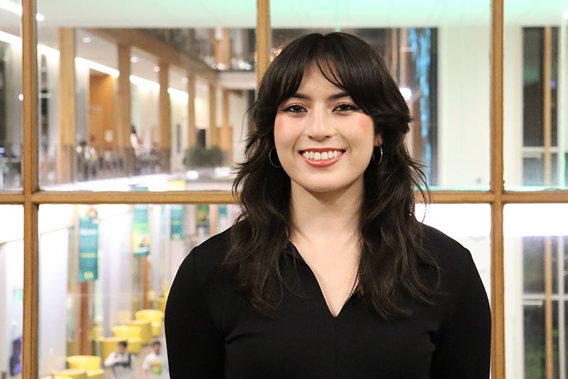 Young woman with long black hair wearing a black blouse