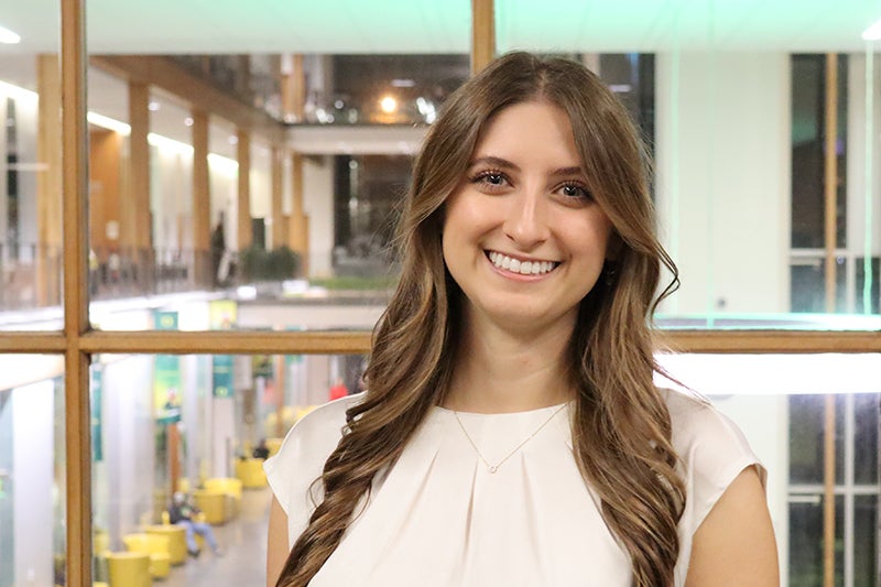 Young woman with long brown hair wearing a white blouse