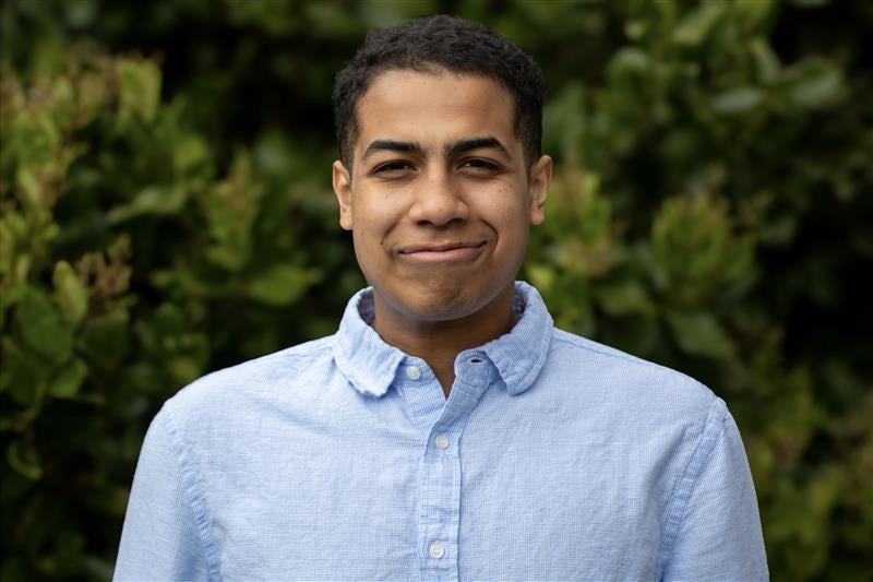 Young man with short black hair wearing a light blue shirt