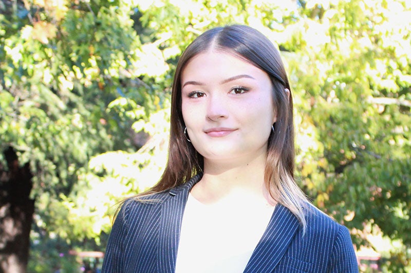 young woman with brown hair wearing a blue blazer
